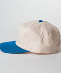 Vintage Style Hat Cerulean Blue and Natural - Beige cap with blue brim on a light gray background