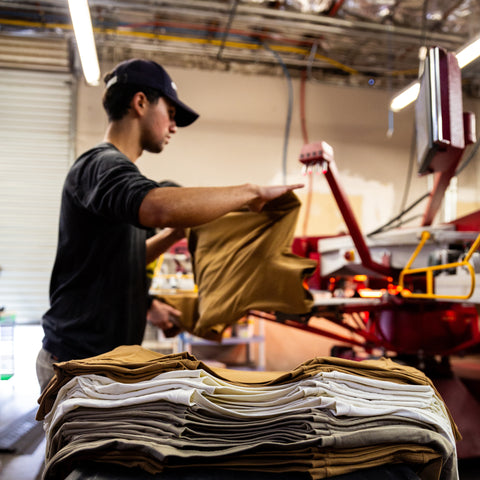 Arroyo MFG Co. warehouse screen printing shirts on the automatic press