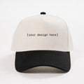 White and black cap with 'your design here' text on a white background