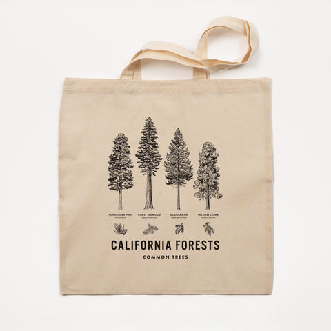Beige tote bag with black tree illustrations and text on a white background