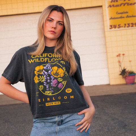 Woman wearing a black t-shirt with a colorful graphic design in an urban setting