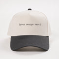 White and black cap with 'your design here' text on a white background