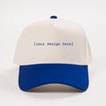 White and blue cap with 'your design here' text on a white background