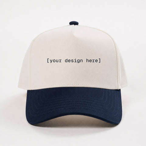 White and navy cap with 'your design here' text on a white background