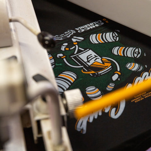 Close-up of a Sierra Nevada Brewing Co Beer Camp Shirt with a design on a dark surface, featuring a brand logo.