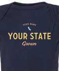 Detail shot of custom baby onesie reading "your name, your state, grown" and a US state silhouette