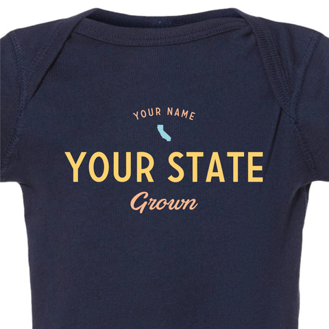 Detail shot of custom baby onesie reading "your name, your state, grown" and a US state silhouette