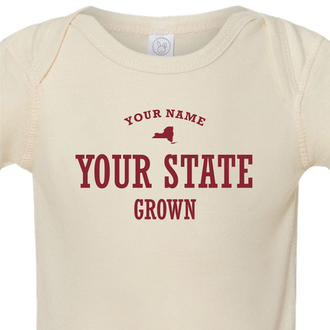 Detail shot of custom baby onesie reading "your name, your state, grown" and a US state silhouette